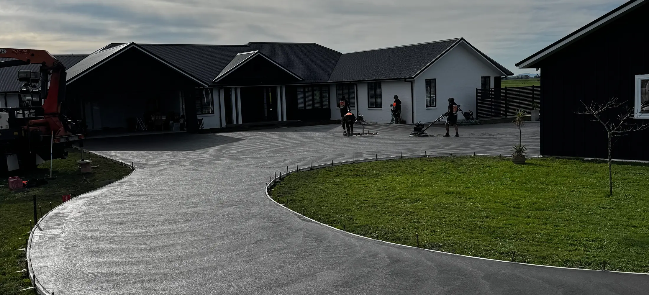 Sweeping curved concrete driveway with a swirl finish laid in front of a home