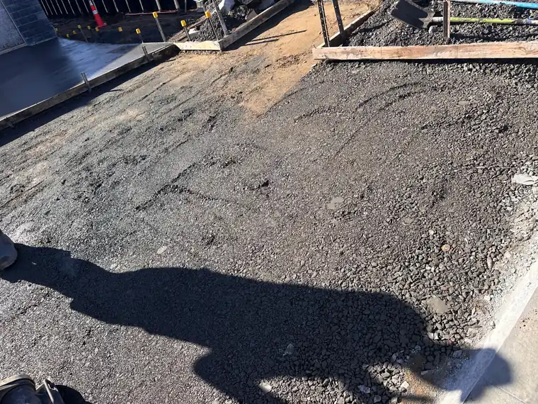 Basecourse compacted and boxed ready for concrete alongside an existing path