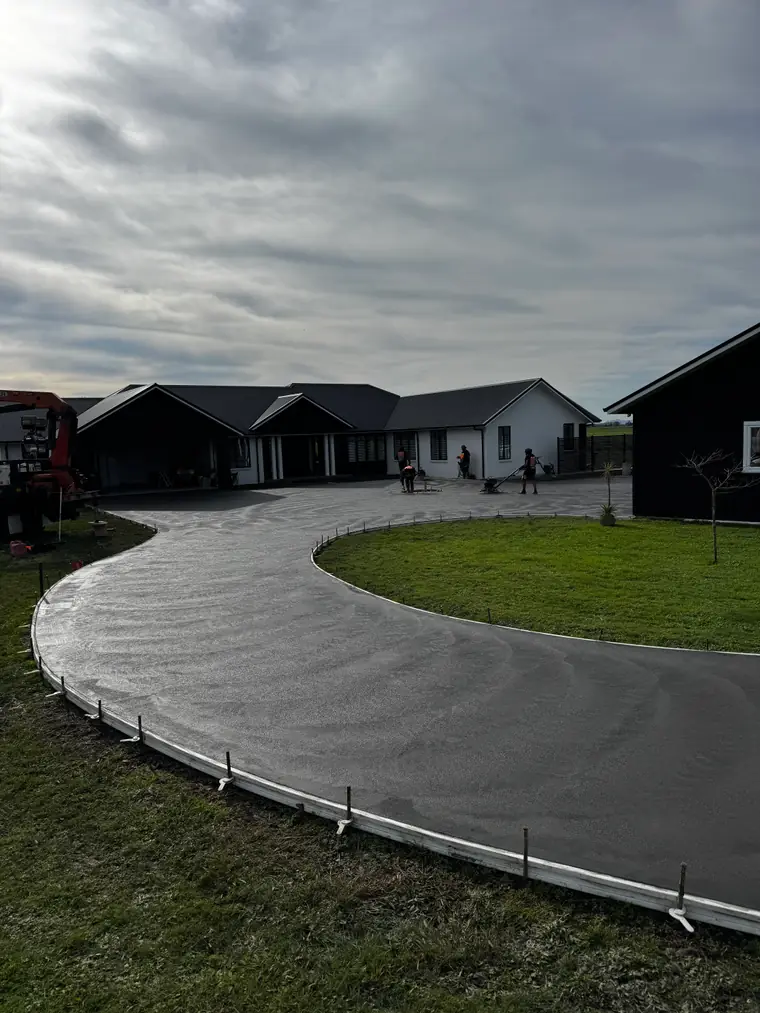 Sweeping curved concrete driveway with a swirl finish laid in front of a home