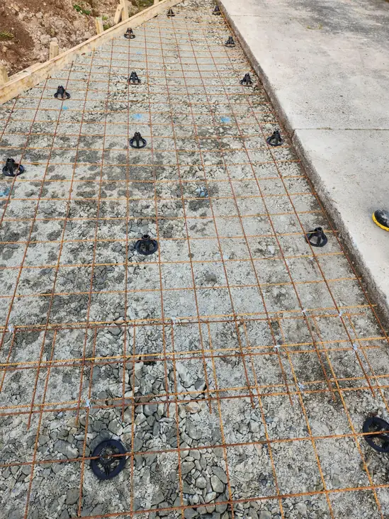 Steel mesh tied over hardfill beside an existing concrete path before the pour